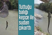Yakaladığı balığı kepçe ile çıkarttı